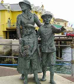 Statue of Annie Moore with her brothers, Cobh, Co Cork copyright Bkkbrad cc3