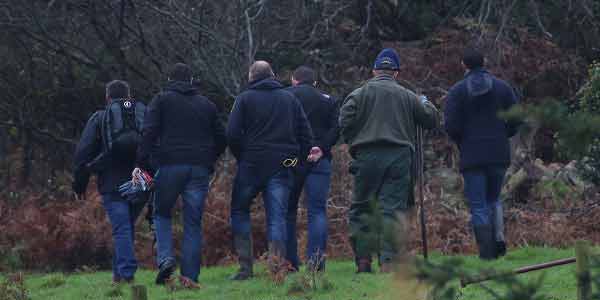 Police search land around the border after discovery of arms dump