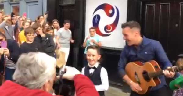 Irish folk singer surprises young fan by sneaking onstage with him